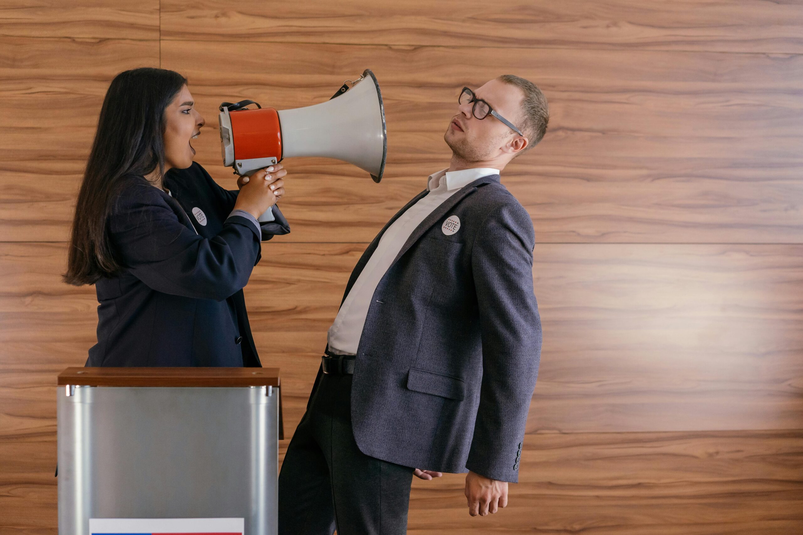 Woman shouting in a megaphone towards a man